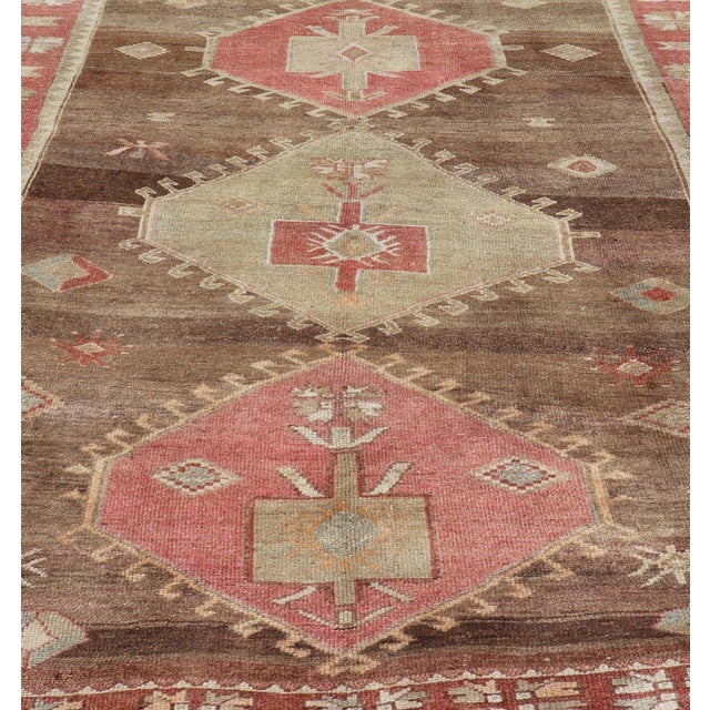 Measures: 8'2 x 11'10 This Vintage Turkish Kars Tribal Rug captivates with its earthy palette and bold tribal patterns,...