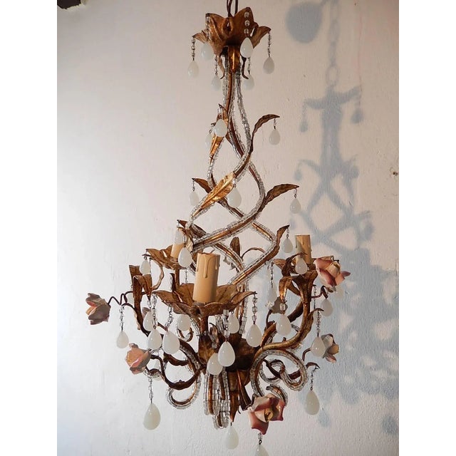 Housing three lights, rewired and ready to hang. Gilt tole beaded with crystal macaroni beads. Adorning handmade porcelain...