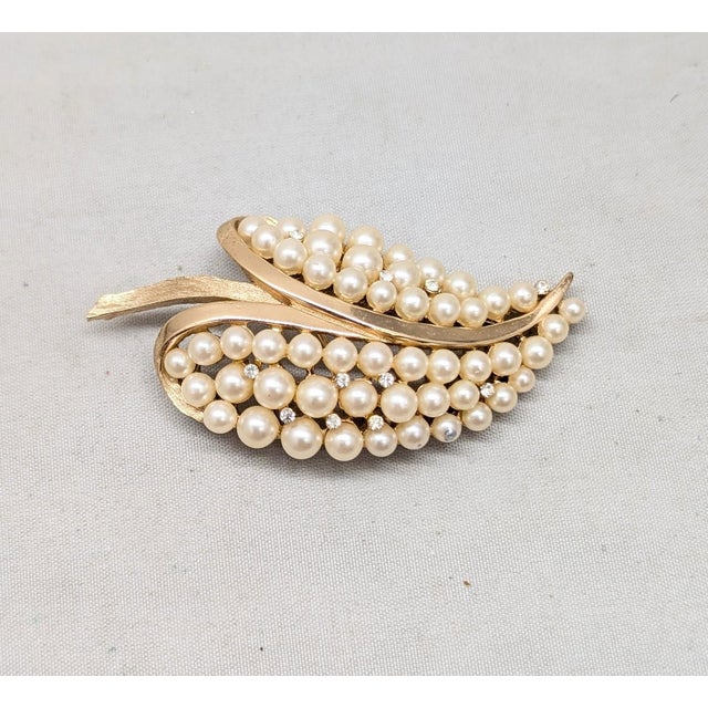 1960s goldtone faux-pearls and small round clear rhinestone accents in the shape of a leaf brooch with security clasp....