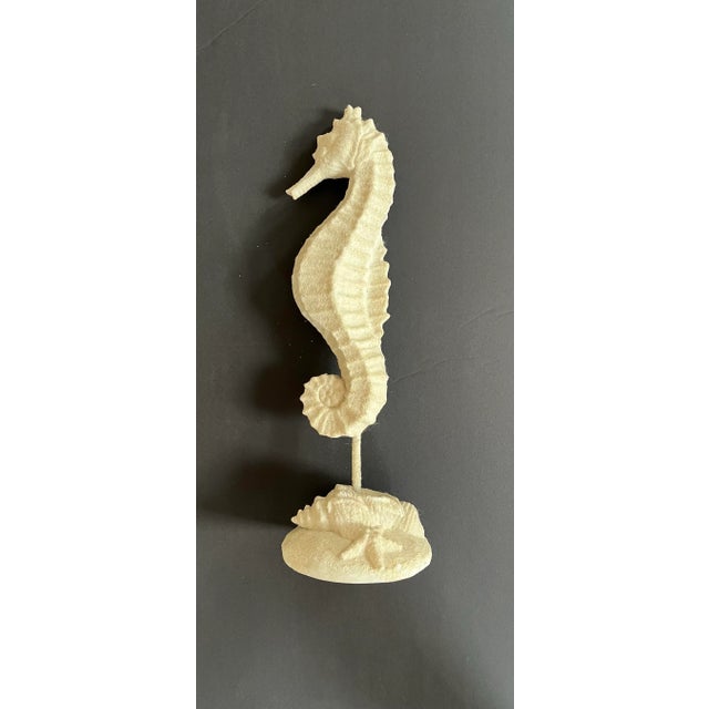 A striking coastal seahorse sculpture featuring a textured sand finish and detailed shell base. Standing 14 inches tall,...