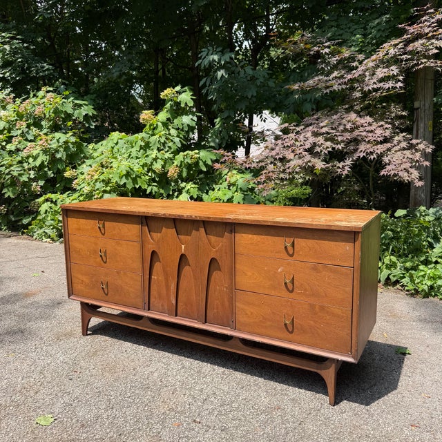 This walnut Broyhill Brasilia 9-drawer lowboy dresser feature sculpted cabinet doors and brass hardware the Brasilia...
