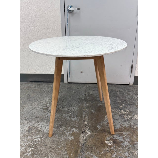 Design Plus Gallery presents the Mara Café Table from Article. This contemporary round table pairs a white Carrara marble...