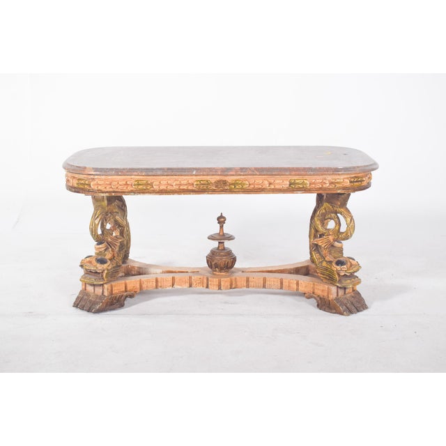 Coffee table with marble top. With a richly carved structure, the highlight of the piece is the sculptural base with...