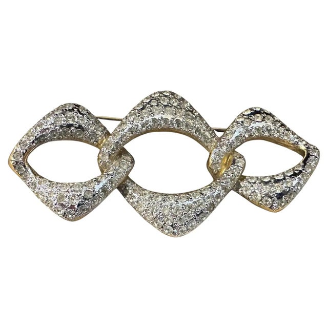 This 1990s Yves Saint Laurent (YSL) costume jewelry brooch is an exquisite example of the bold, glamorous aesthetic for...