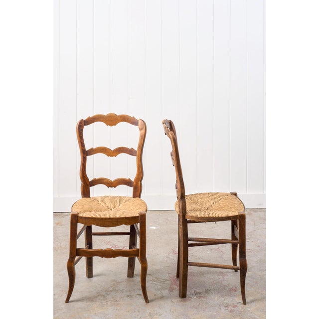 This set of 6 antique French ladder-back chairs are full of charm and character. The solid wood frames feature a warm wood...