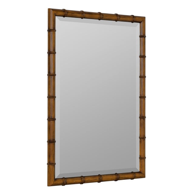 The Theodore Wall Mirror features a rich brown resin frame with bamboo-inspired detailing and beveled glass for an...