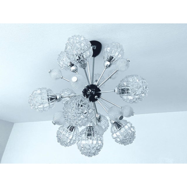 Large Sputnik pendant light featuring 25 spokes mounted on a black enameled core and glass shades. Dimensions 76 cm /...