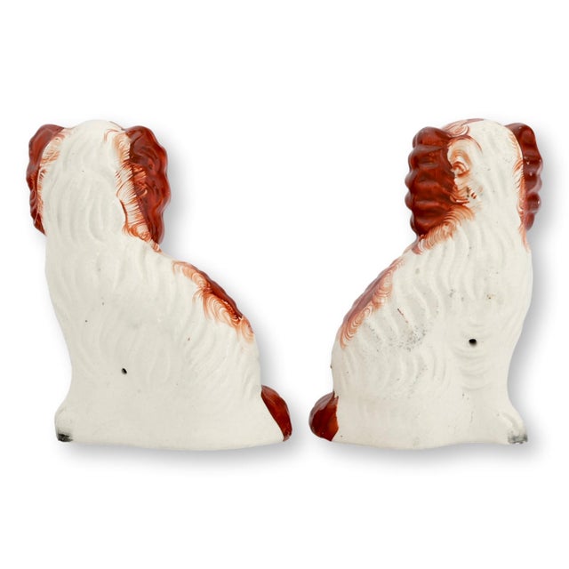 Mid 19th century Staffordshire pottery King Charles spaniel dogs modeled in the traditional seated form with expressive...