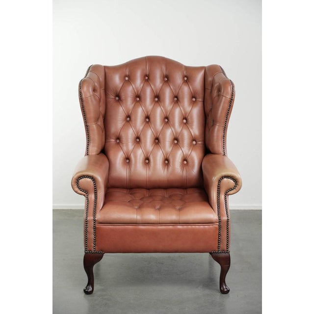 This classic English cowhide leather button seat Chesterfield wing armchair features a beautiful patina and lovely colors....