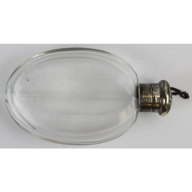 A sterling cap clear glass flask. Dimensions: 5 1/8"H x 3 1/8"W x 1"D