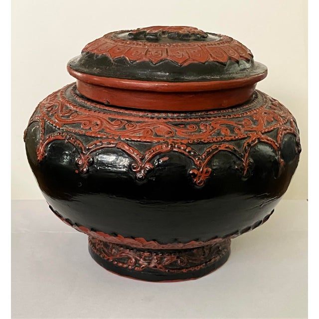 Antique Burmese Lacquer Lidded Jar — A striking handcrafted vessel featuring a raised elephant motif on the lid, encircled...