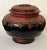 Antique Burmese Lacquer Lidded Jar — A striking handcrafted vessel featuring a raised elephant motif on the lid, encircled...