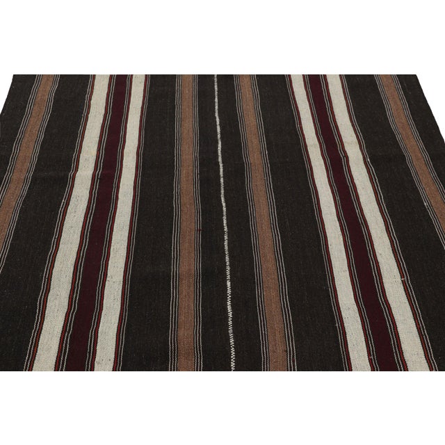 Handwoven in a wool flatweave originating from Turkey circa 1950-1960, this 5x7 vintage Kilim rug connotes a mid-century...