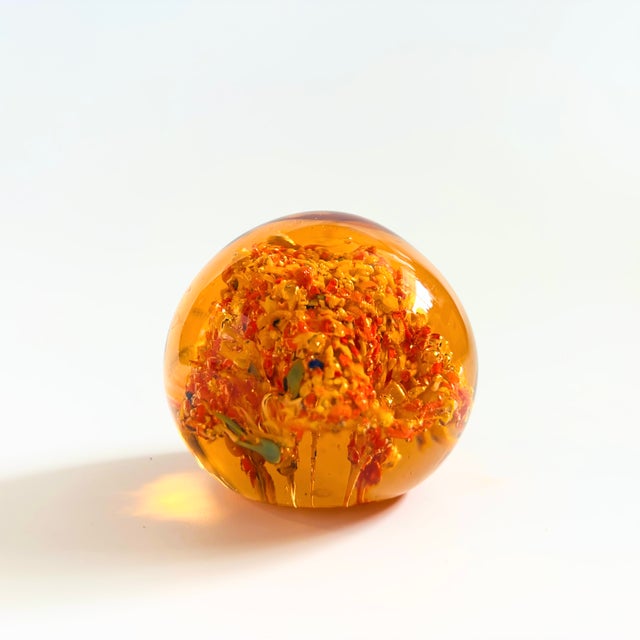 A lovely vintage art glass paperweight in a lovely orange color. Measures 2"Dia x 1.75"H