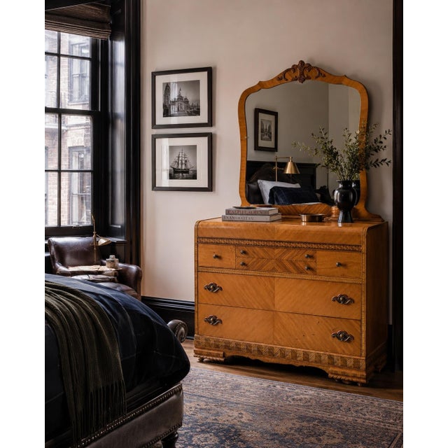 A beautifully crafted late 1930s Art Deco dresser with its original matching mirror, distinguished by book-matched...