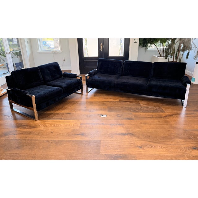 A striking vintage lounge set featuring sculptural chrome sled bases paired with deep, plush/shag black upholstery....