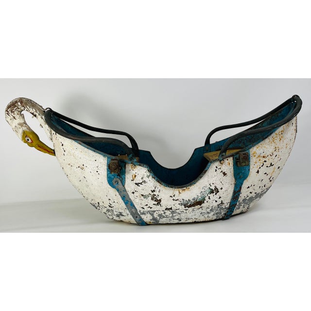 A beautifully timeworn children’s ride-on toy crafted in the evocative shape of a swan, likely dating back to the early to...
