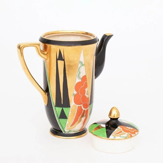 H: 20cm W: 17cm D: 10cm An art deco Crown Devon Orient design coffee pot with 22ct gilt and enamelled decoration designed...