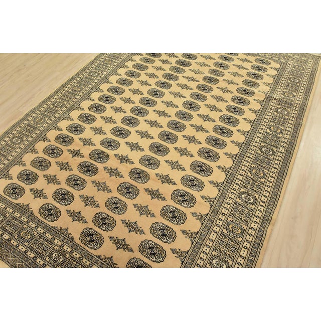 A tribal Bokhara rug hand-knotted with fine wool on a cotton foundation. This rug features rows of repeating medallions...