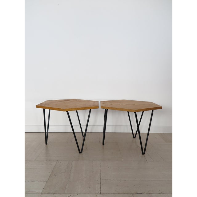 Pair of coffee tables designed by Gio Ponti and produced by ISA Italia, with a hexagonal light wood top and black painted...