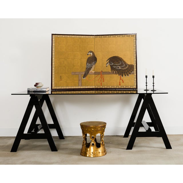 Captivating Japanese Showa period two-panel folding byobu screen featuring a pair of hawks or birds or prey tethered to a...