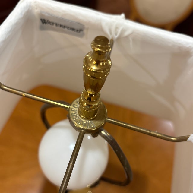 A distinctive Waterford crystal and brass swing-arm lamp featuring a tall cylindrical column of clear lead crystal cut...