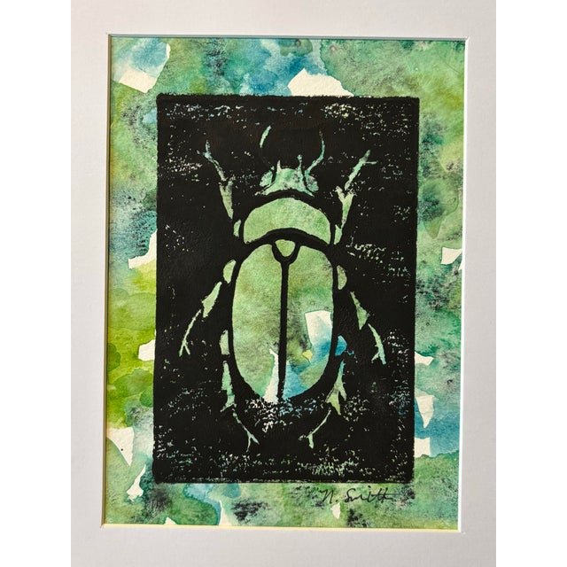 An original hand-carved block linocut featuring a detailed beetle motif, individually printed with black ink and finished...