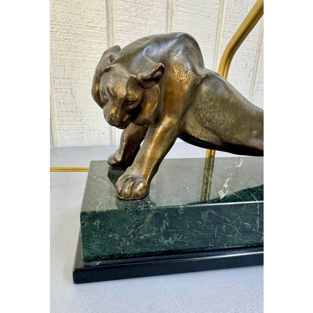 Striking vintage table lamp featuring a stretching lion figure, crafted in bronzed metal (possibly spelter) and mounted on...