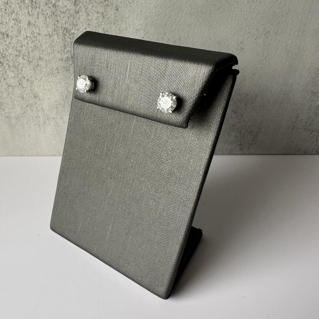 Experience the brilliance and elegance of these Natural Diamond Studs, featuring a total of 1.40 carat total weight (ctw)...