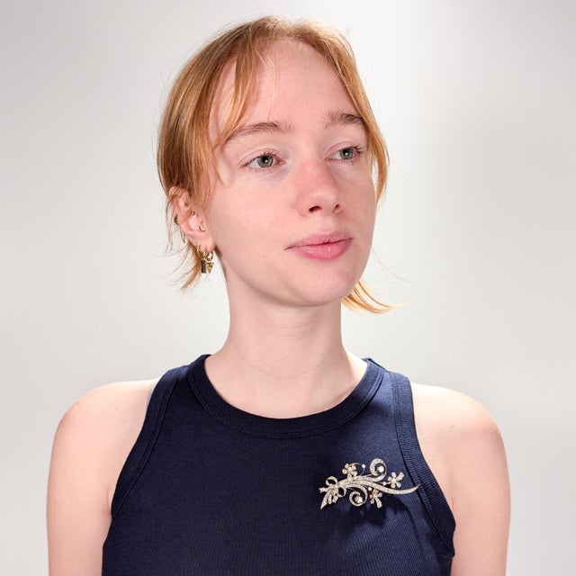 A fine Mid-Century gold, diamond, and pearl brooch. In 14 karat white & yellow gold. In the form of a sprig of flowers...