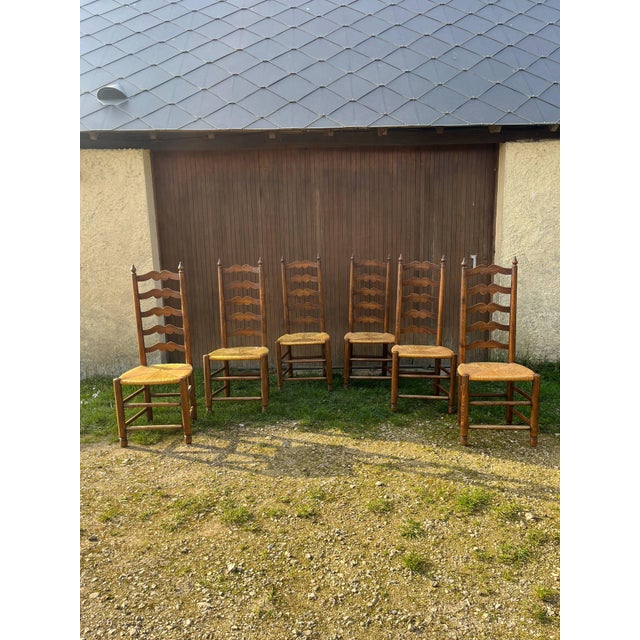 This rare set of six "Ladderback" chairs represents the pinnacle of French provincial mid-century design. Featuring an...