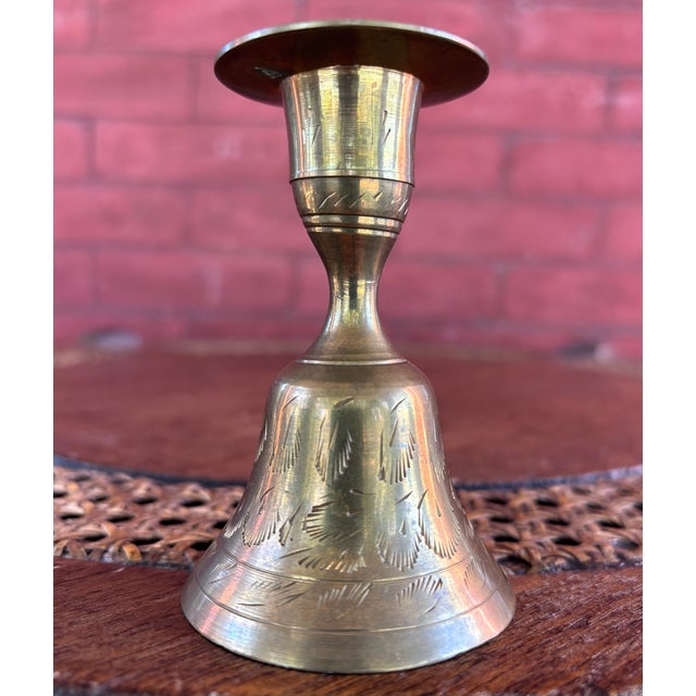 This is a charming vintage brass candlestick featuring a functional bell-shaped base with its original interior clapper....