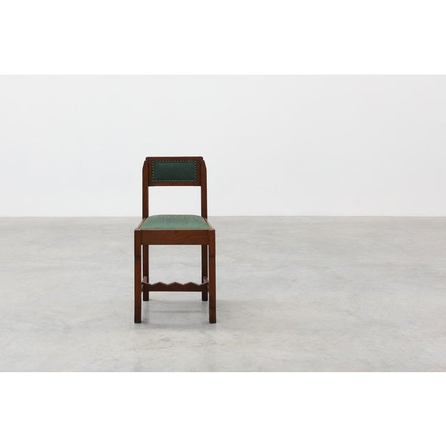 A Belgian Art Deco side chair from the 1920s, crafted in solid oak with a distinctly modernist sensibility. Its geometric,...