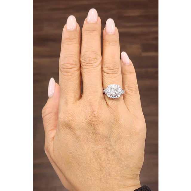 A stunning GIA-Certified 1.10-carat cushion-cut diamond takes center stage, exuding brilliance with its white hue....