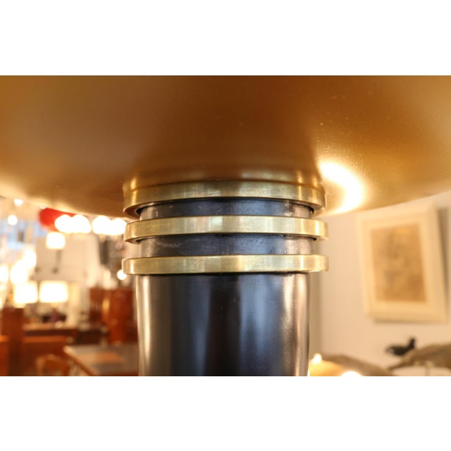 A French Art Deco period torchiere floor lamp from France circa 1930. The conical ebonized shaft stands upon a circular...
