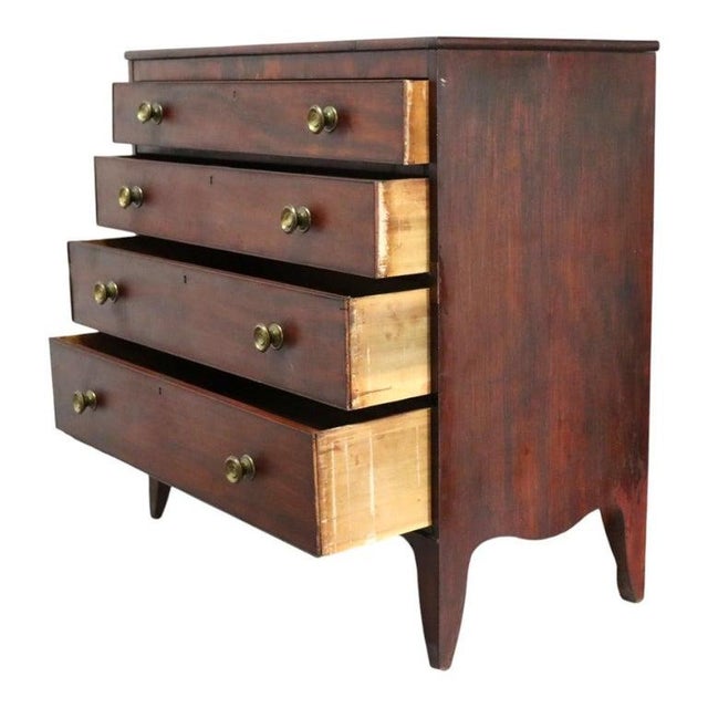 This antique chest of drawers, crafted in the Hepplewhite style, dates to approximately 1830. Constructed from rich...