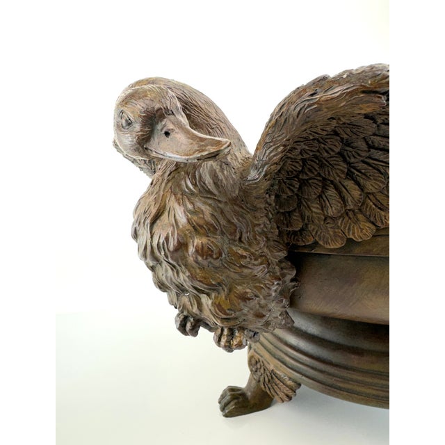 This stately antique-style wooden bowl, adorned with intricate swan carvings on either side, offers old-world charm and...