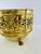 A richly detailed vintage English brass planter featuring a deeply embossed band of scrolling flowers and foliage. The...