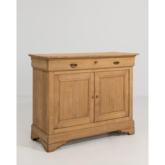 A French oak buffet with a rectangular form and paneled doors. The design is straightforward, focusing on structure and...