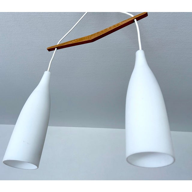 Mid century danish modern pendant light featuring a v shaped teak wood suspension and 3 opaline glass shades very good...