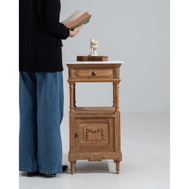 A refined Louis XVI side table featuring a marble top and classic neoclassical structure with straight legs and balanced...