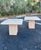 Pair of travertine square side tables in an Italian mid-century style. A unique set with beveled details throughout. Each...
