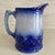 Antique Red Wing stoneware pitcher in flow blue. Heavy pitcher with wave or shell pattern around the base.