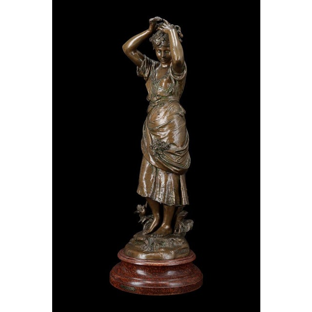 - the work: this spelter sculpture entitled mirror, signed auguste moreau, depicts a young woman in a rustic dress, her...