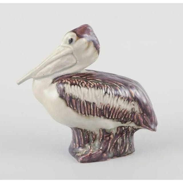 Jeanne Grut for Royal Copenhagen, ceramic pelican figurine. Glaze in brown tones. Model number 22296. Mid-20th century....