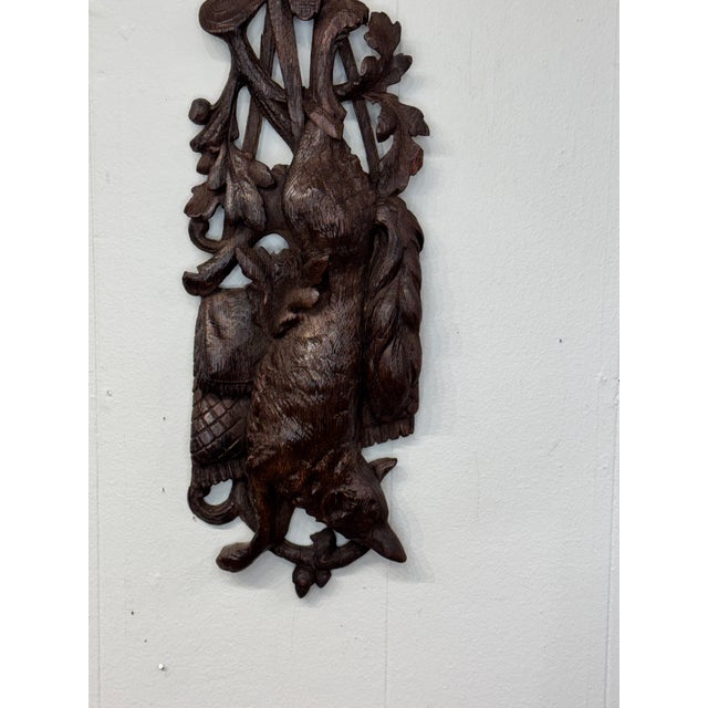 This is a dark wood Black Forest Carved Wall Plaque depicting a fox and hunting theme. It is expertly carved with leaves...