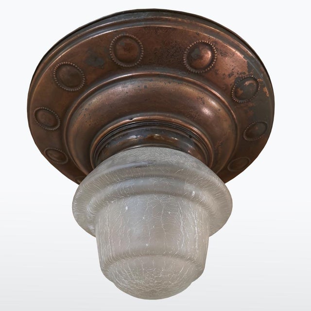 Early 20th-century Art Nouveau copper flush-mount ceiling light with embossed decoration and a frosted, crackled glass...