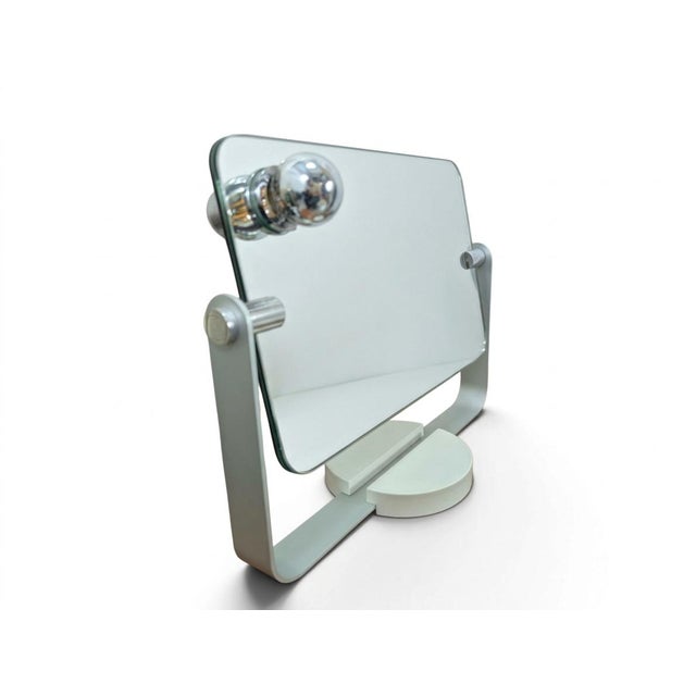 This adjustable table mirror features a modern, minimalist design, featuring a light gray metal support structure and a...