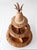 A vintage mid-century tiered lazy Susan featuring intricately carved tropical motifs, a decorative pineapple finial, and...