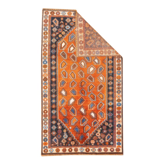 Antique hand-knotted Persian Qashqai rug with an elongated diamond medallion set within an orange field containing...
